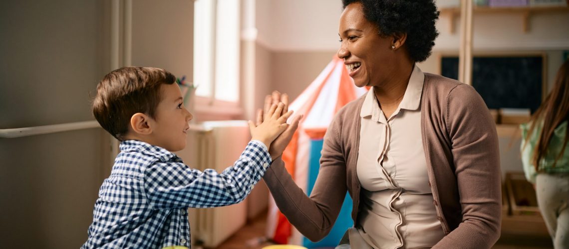 Happy,Little,Boy,Giving,High-five,To,His,African,American,Teacher